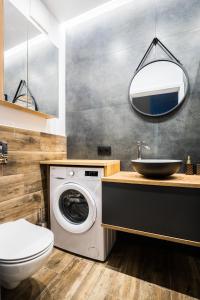 a bathroom with a washing machine and a sink at VipWarsawApartments Cytryn Mennica Residence in Warsaw +49 photos