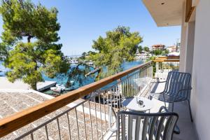 balkon z 2 krzesłami i widokiem na wodę w obiekcie Medusa Luxury Suites w mieście Neos Marmaras