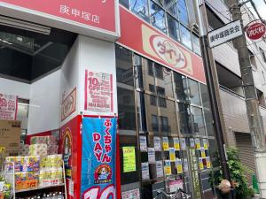 una tienda con letreros al lado de un edificio en Aurora 3, en Tokio