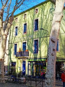 een groen gebouw met een boom ervoor bij LA MAISON VERTE SETE in Sète