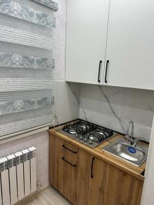 - une cuisine avec un évier, une cuisinière et des placards dans l'établissement 3х комнатная квартира, à Chimkent