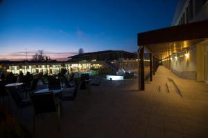 Hotel Village في أوخريد: فناء على السطح مع طاولات وكراسي في الليل
