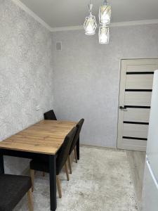 - une salle à manger avec une table et des chaises en bois dans l'établissement 3х комнатная квартира, à Chimkent
