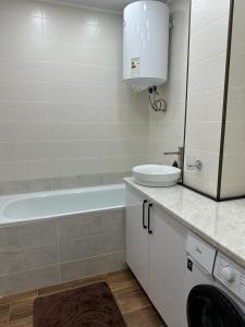 La salle de bains est pourvue d'un lavabo, d'une baignoire et de toilettes. dans l'établissement 3х комнатная квартира, à Chimkent