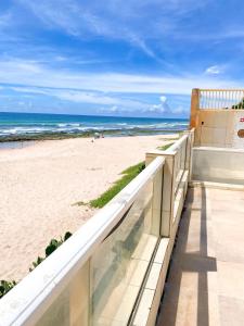 een balkon met uitzicht op het strand bij Ondas de Marina pé na areia - BAHIA in Lauro de Freitas