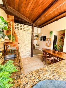 een keuken en eetkamer met een houten plafond bij Ondas de Marina pé na areia - BAHIA in Lauro de Freitas