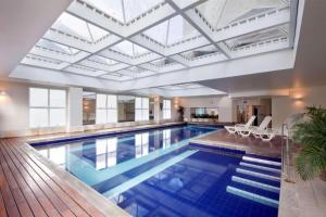 a large swimming pool with a large ceiling at Apto no Comfort Suites COM CAFÉ E ESTAC Incluso in Barueri