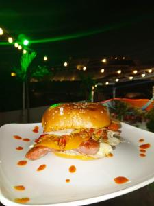 un sándwich con tocino y queso en un plato blanco en Del Castillo Mirador Hostel en Cartagena de Indias