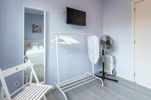 Zimmer mit einem weißen Zimmer mit einem Bett und einem Spiegel in der Unterkunft GuestReady - Wellspring Bloom in Porto