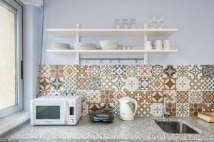 eine Küchentheke mit Mikrowelle und Spüle in der Unterkunft GuestReady - Wellspring Bloom in Porto