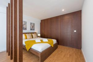 1 dormitorio con 1 cama con pared de madera en GuestReady - Aptos do Hemisfério, en Oporto
