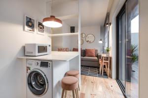 a kitchen and living room with a washing machine in a room at GuestReady - Three Mirrors in Porto +22 photos