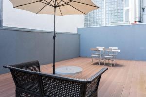a table and chairs with an umbrella on a patio at GuestReady - Three Mirrors in Porto