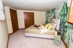 - une chambre avec un lit et du papier peint tropical dans l'établissement Luxury Mountain Mansion Huge Pool, Sauna, 7000sqft, à Windham