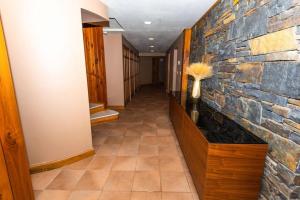 un long couloir avec un mur en pierre et un sidx sidx sidx dans l'établissement Luxury Mountain Mansion Huge Pool, Sauna, 7000sqft, à Windham