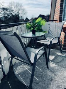 two chairs and a table on a balcony with a potted plant at Apartment 160qm 5 Schlafzimmer 1 Wohnzimmer Terrasse und Balkon in Wilhelmshaven