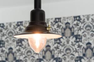 a light hanging from a ceiling with a wall at GuestReady - Impulso Aventureiro in Porto
