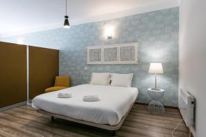 1 dormitorio con 1 cama grande y pared azul en GuestReady - Impulso Aventureiro, en Oporto