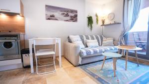 een woonkamer met een bank en een tafel en stoelen bij Horizon Vue mer 180° in Saint-Raphaël