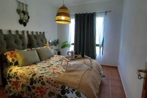 una camera da letto con un letto con un piumone e una finestra di My casa Lanzarote a Costa Teguise Altre 14 foto