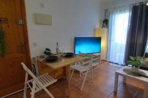 a room with a desk with a television and chairs at My casa Lanzarote in Costa Teguise