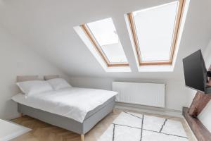 a white bedroom with a bed and two windows at Apartament Ultra-Central Premium cu Parcare Gratuita pe Malul Crisului in Oradea
