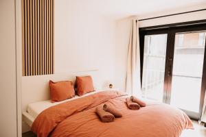 a bedroom with a bed with two slippers on it at Ostend Centre Bayview Apartment + Free Parking in Ostend