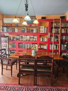 a dining room with a table and chairs and bookshelves at Terrazza 14, Family house in Elefsina in Eleusis