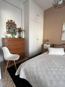um quarto com uma cama, um espelho e uma cadeira em Sea View Apartments near Athens Airport em Artemida