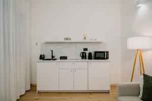 a white kitchen with a counter and a couch at Alatea Apartments Valverde in Verona