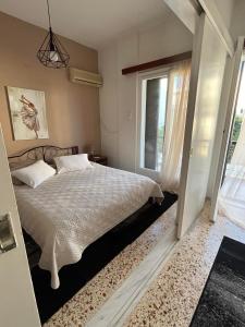 a bedroom with a bed and a window at Sea View Apartments near Athens Airport in Artemida