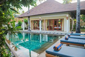 a swimming pool in front of a house at Dolce Magia in Gili Trawangan