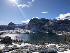 een meer in de bergen met sneeuw op de grond bij Hotel Alda in Avín