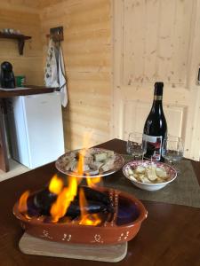 una mesa con chimenea con platos de comida y una botella de vino en One bedroom property with enclosed garden and wifi at Falgaroso Da Serra Mortagua en Mortágua