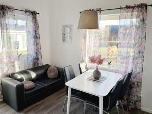 un soggiorno con divano in pelle nera e tavolo di Newly built guest house located in Vimmerby a Vimmerby