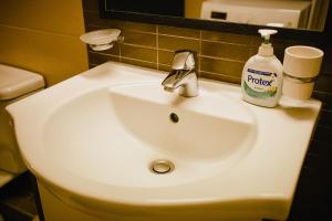 a white bathroom sink with a bottle of soap on it at Privilegio apartment - Centru Civic - Afi Mall in Braşov
