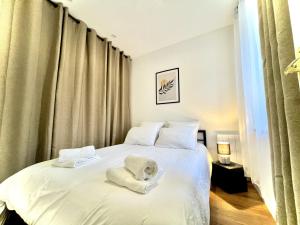 1 dormitorio con 1 cama con toallas en Les Logis d'Esmeralda-Des appartements au charme intemporel, en Romorantin-Lanthenay