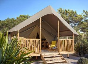 a tent with a chair in front of it at Le Vallon aux merlettes in Matignon