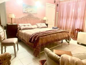 a bedroom with a bed and a couch and chairs at CasAzzurra in Ortona