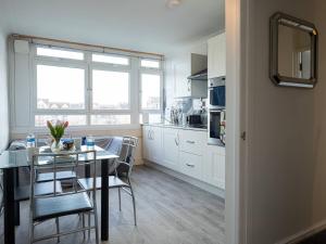 a kitchen and dining room with a table and chairs at Pass the Keys Riverfront Comfort by the Thame in London