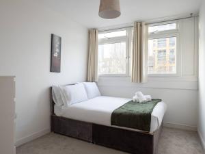 a small bed in a room with a window at Pass the Keys Riverfront Comfort by the Thame in London
