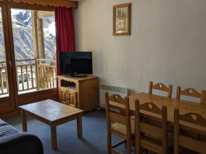 a living room with a television and a dining room table at Appartement Orcières Merlette, 3 pièces, 6 personnes - FR-1-262-154 in Les Estaris