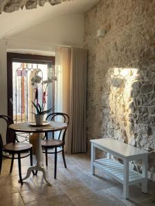 a table and chairs in a room with a stone wall at ArcoMare Suite in Giovinazzo
