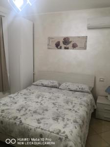 モンテ・サン・ビアージョにあるMagia sul Lago di Fondiのベッドルーム1室(ベッド1台付)が備わります。壁に絵が飾られています。