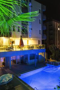 um hotel com piscina à noite em Luna Lara Hotel em Antália