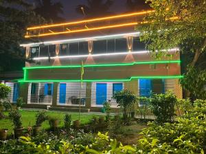 a building with neon lights on the side of it at Labanya Lodge in Konārka