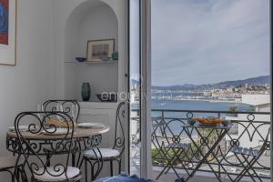 a room with a balcony with a table and chairs at Palais Miramar - Suite & G17 - Vue Mer - Croisette Emplacement Unique -20 Plage - WIFI - Clim in Cannes