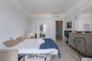 una camera da letto con un letto e una TV di Palais Miramar - Suite & G17 - Vue Mer - Croisette Emplacement Unique -20 Plage - WIFI - Clim a Cannes