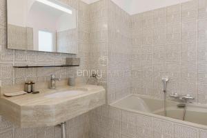 un bagno con un lavandino, una vasca e uno specchio di Palais Miramar - Suite & G17 - Vue Mer - Croisette Emplacement Unique -20 Plage - WIFI - Clim a Cannes