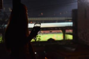 a woman holding a cell phone in front of a soccer game at 4Room Hotel in Yerevan